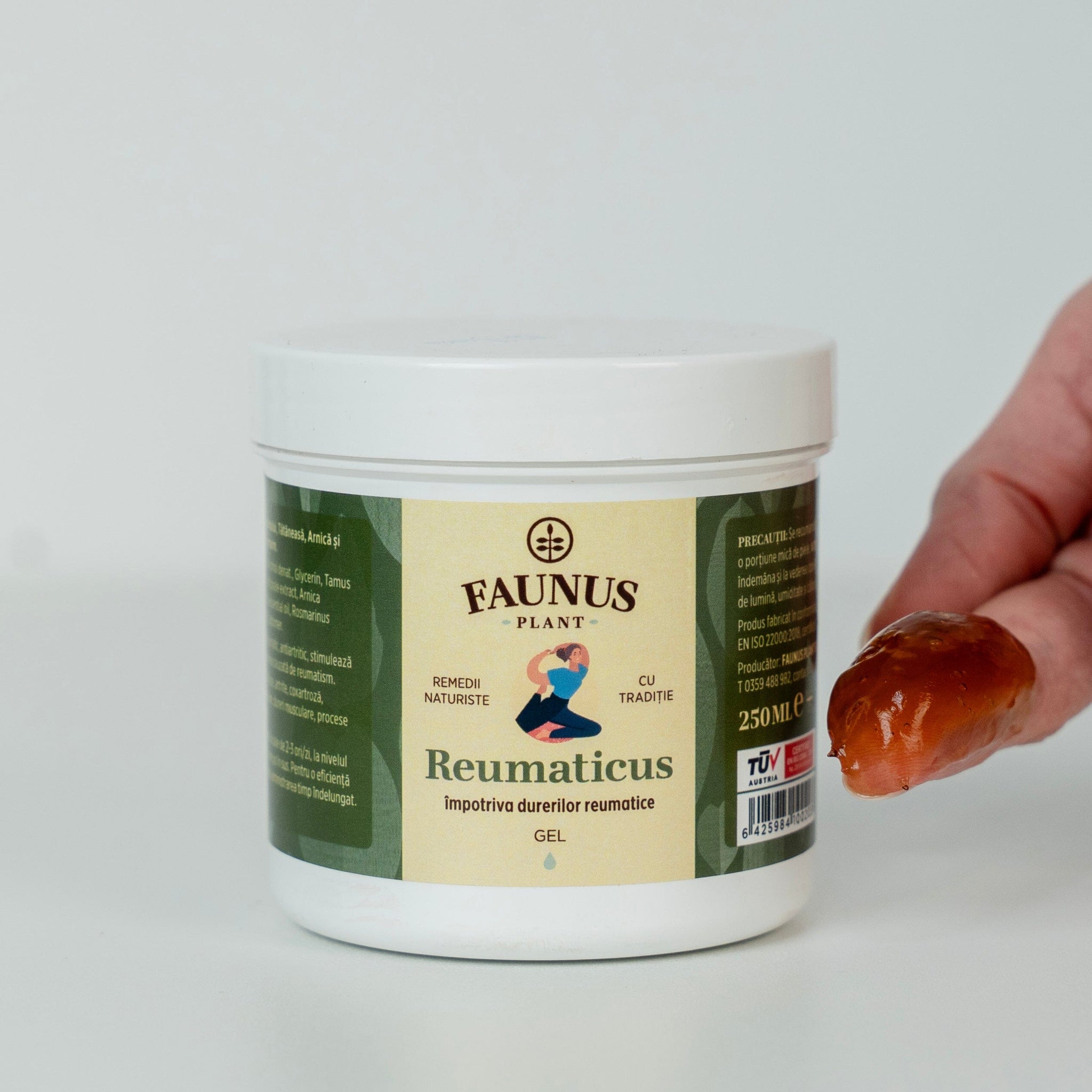 Gel Reumaticus de la Faunus Plant, ambalat într-un recipient alb de 250 ml, alături de o mână care prezintă textura gelului, de culoare brună, semn al ingredientelor naturale din compoziție. Eticheta indică utilizarea împotriva durerilor reumatice și sigla TÜV Austria pentru certificare de calitate.