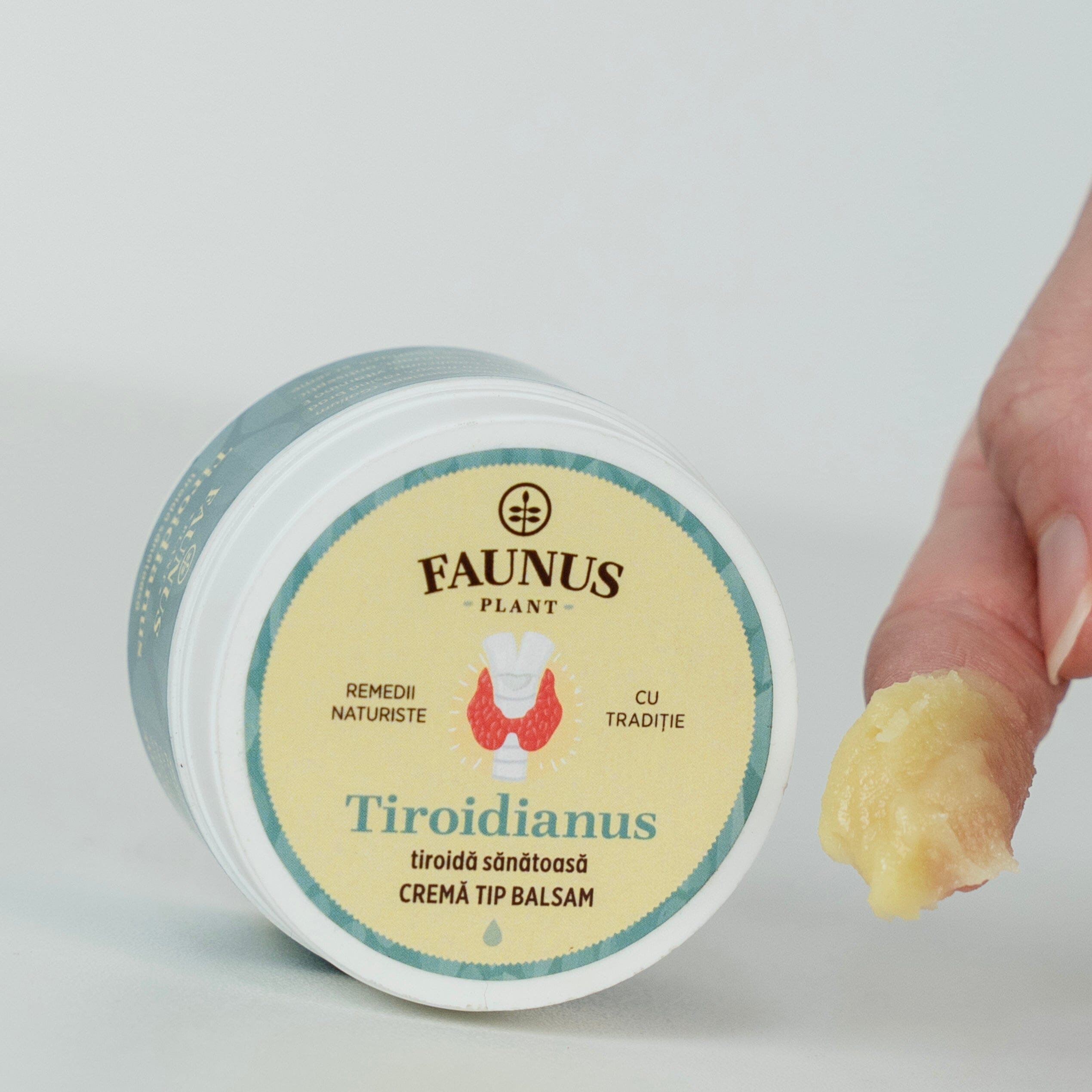 Textură Cremă Tip Balsam Tiroidianus de la Faunus Plant, cremoasă și densă, aplicată pe deget, detaliu al produsului pentru utilizare locală.